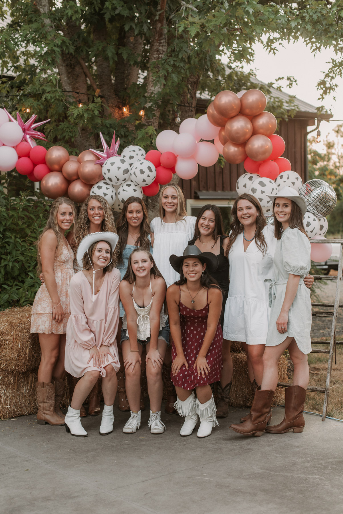 A group of women smile at the camera wearing cowboy hats