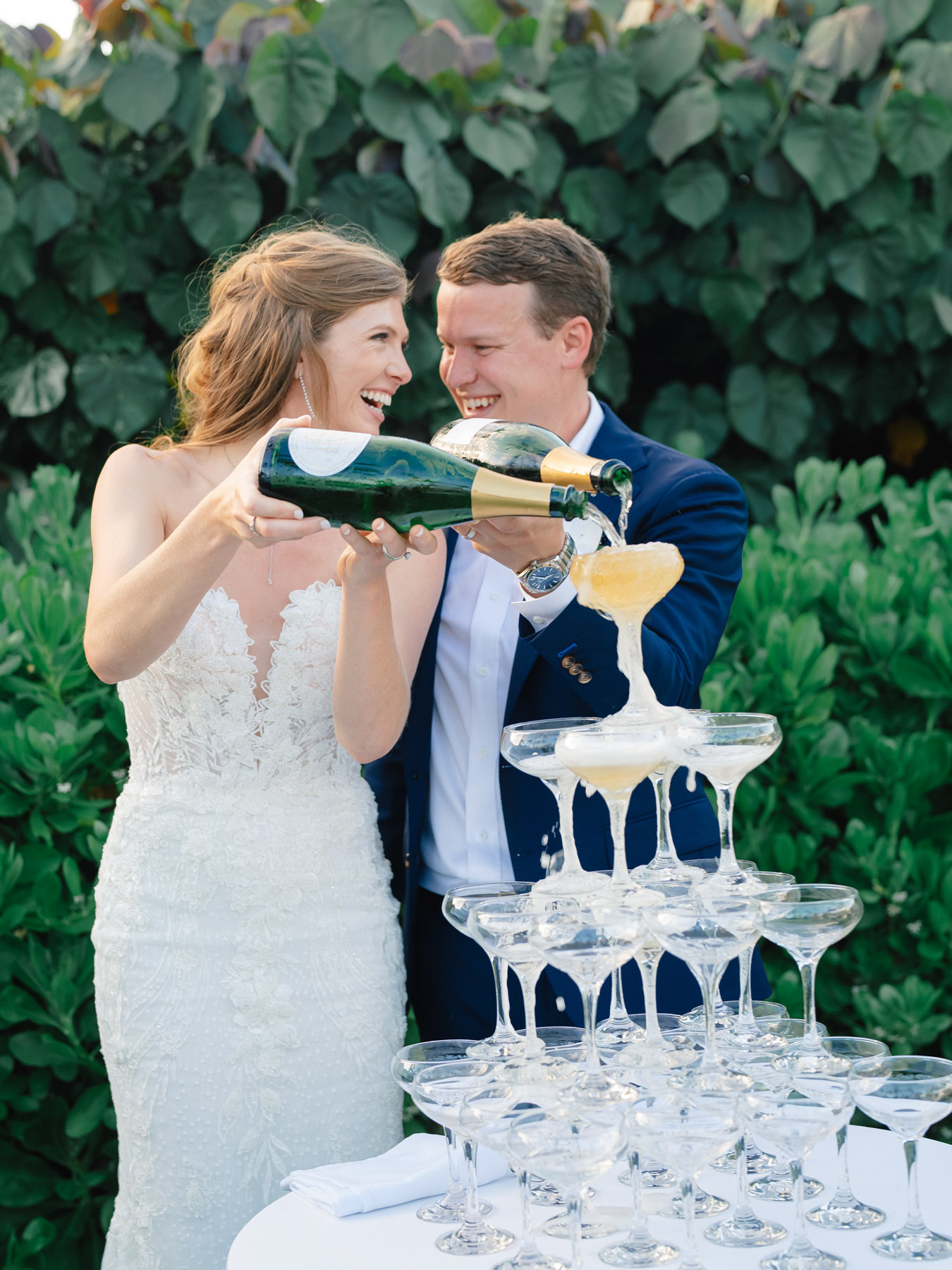 A bride and groom pouring champagne into glasses