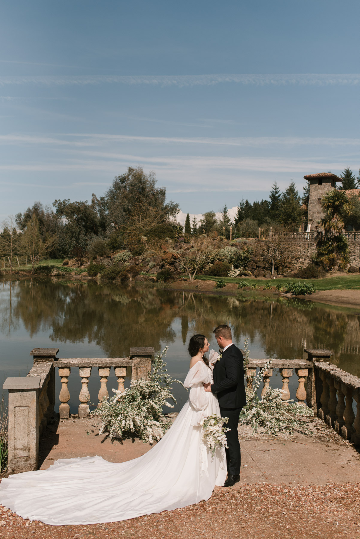A bride a groom standing in front of Villa Catalana Cellars